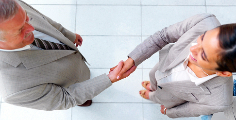 Top view of a smiling business man and woman shaking hands